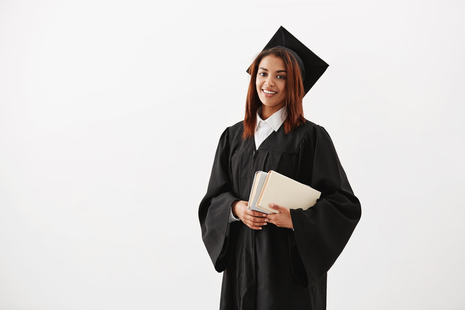 Jeune diplômée souriante tenant des livres