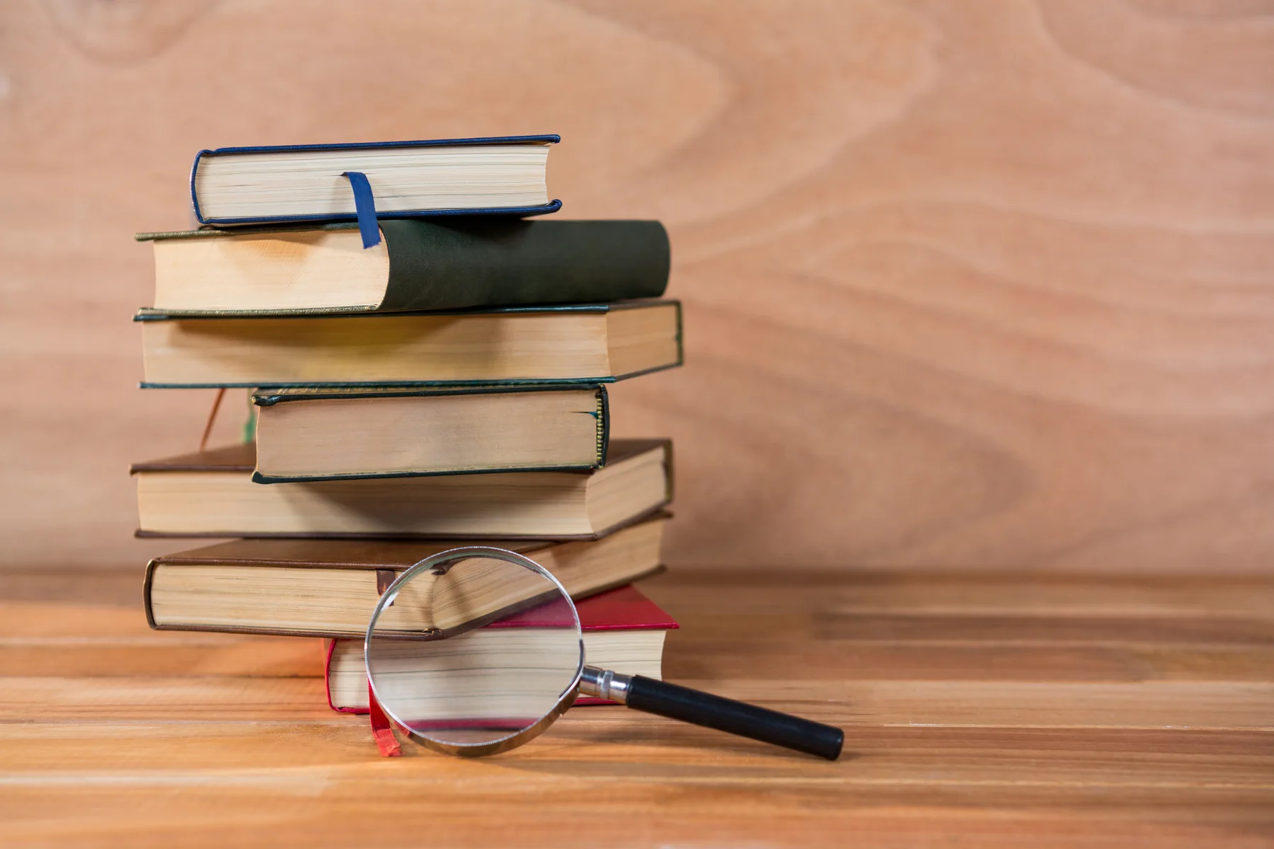 Livres et loupe représentant la recherche et l’analyse des sources