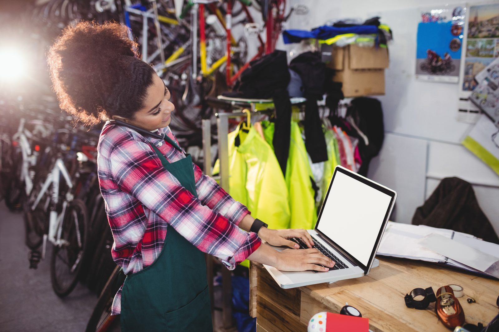 Commerçante gérant son atelier tout en travaillant sur son ordinateur portable